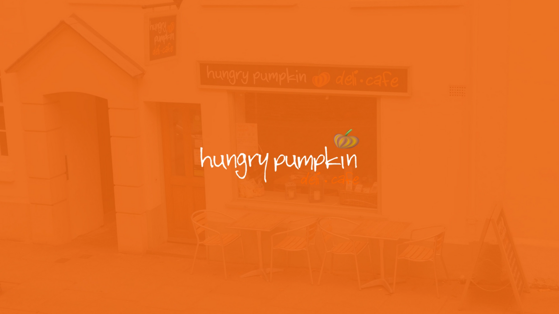 Hungry Pumpkin logo with the shop faintly in the background
